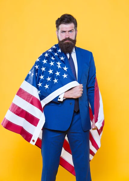 국기는 그의 자부심입니다. 독립 기념일에 미국 국기를 들고 수염을 기고한 남자. 국기의 날을 축하하는 애국 사업가. 미국 국기가 있는 포멀웨어에 자신감 있는 힙스터 — 스톡 사진
