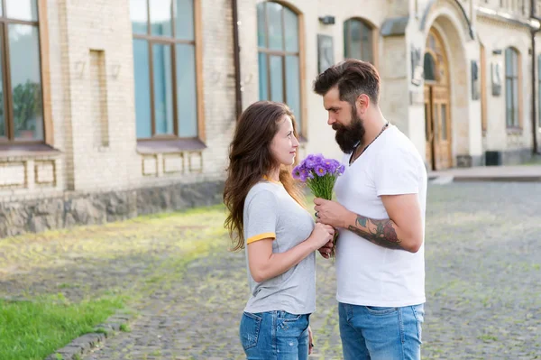 Réunion de couple pour un rendez-vous. Cadeau de bouquet. Homme donnant bouquet de fleurs. Un rencard romantique. Guy a préparé un bouquet surprise pour sa copine. De vrais sentiments. Ramasser une fille pour un rendez-vous. Barbu hipster tomber amoureux — Photo