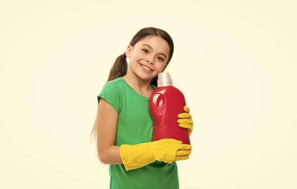 Blanchiment de ménage. Petit enfant prêt à faire la lessive. Petite femme de ménage tenant une bouteille de détergent dans les mains. Jolie aide domestique portant des gants en caoutchouc jaune. Utilisation de produits de nettoyage ménagers — Photo