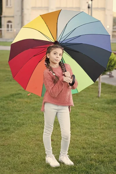 Under big umbrella. Colorful accessory for cheerful mood. Girl child long hair walking park with umbrella. Stay positive and optimistic. Colorful accessory positive influence. Bright umbrella