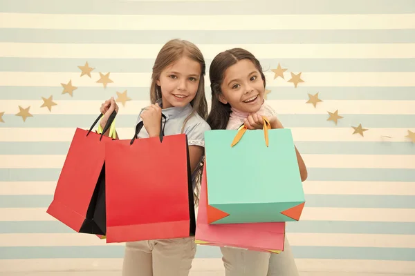 沉迷于购物和服装商场。折扣概念。可爱的小女孩拿着购物袋。购物打折季节。一起度过美好的时光。满足于购物的儿童赤条条背景 — 图库照片