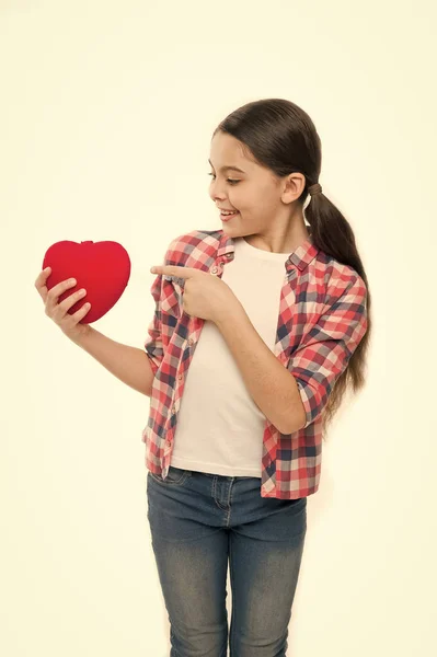 Cute girl in love. Little girl pointing finger at red heart. Little child expressing love on valentines day. Having heart problem and heartache. Happy valentines day. A kind heart
