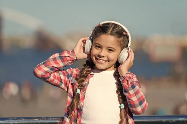 Uroczy meloman. Dzieciak lubi słuchać muzyki. Dziewczynka w słuchawkach stereo. Małe dziecko z bezprzewodowymi słuchawkami. Małe dziecko korzystające z technologii w celach rekreacyjnych lub muzycznych — Zdjęcie stockowe