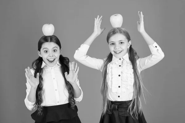 Deja que la comida sea la medicina. Niñas tomando bocadillos escolares. Niñas pequeñas que comen alimentos naturales de vitaminas. Lindas colegialas sosteniendo manzanas. Niños en edad escolar con bocadillos saludables. Las frutas son ricas en vitamina —  Fotos de Stock