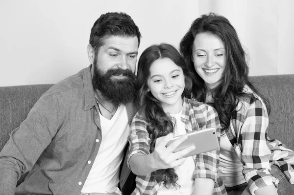 Küçük kız anne ve babasıyla smartphone kullanın. Sakallı erkek ve kadın küçük kız ile. Annem ve babam selfie için küçük kız olun. Küçük kız ailesiyle. Evde mutlu bir aile. Filme — Stok fotoğraf