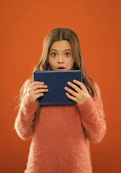 No way. Girl hold book orange background. Child show book notepad. Book store concept. Free book available to read. Interesting literature. Development and education. Child care and happy childhood