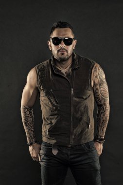 Tıraşsız yüzündeki sakallı dövme modeli. Güçlü silah dövme sakallı adam. Pazı ve triceps dövmeli adam. Moda maço trendy güneş gözlüğü. Moda stil ve trend, vintage filtre