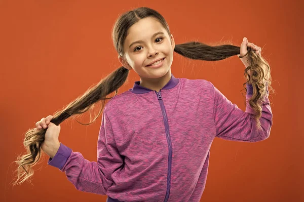 Small child long hair. Charming beauty. Girl active kid with long gorgeous hair. Strong and healthy hair concept. How to treat curly hair. Nice and tidy hairstyle. Easy tips making hairstyle for kids