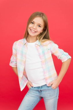 Neşeli bir gülümseme. Mutlu çocukluk. Kız sevimli çocuk yüz ifade kırmızı arka plan gülümseyen. Olumlu duygular kavramı. Mutlu çocuklar günü. Her gün mutlu olmak. Schoolgirl rahat tarzı duygusal çocuk