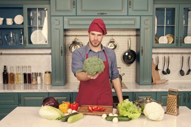 Vejetaryen diyet kavramı. Mutfak tarifi. Şef pişirme Vejeteryan tarifi. Vejetaryen mutfağı zengin vitamin. Adam şef mutfakta yemek önlük giymek. Taze sebze ile adam cook vejetaryen tarifi