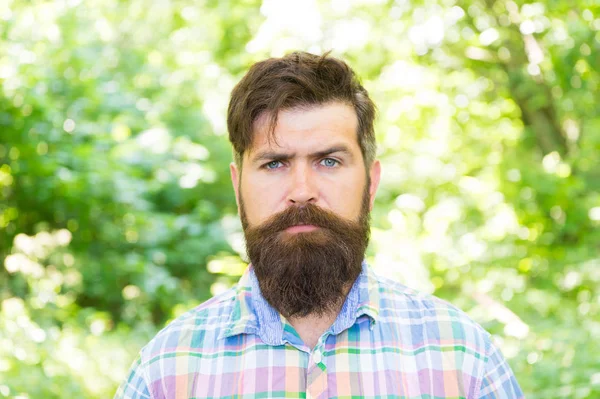 Handsome lumberjack. Man beard and mustache in summer forest. Hike and travel. Summer vacation concept. Man bearded hipster green trees background. Guy relax in summer nature. United with environment — Stock Photo, Image