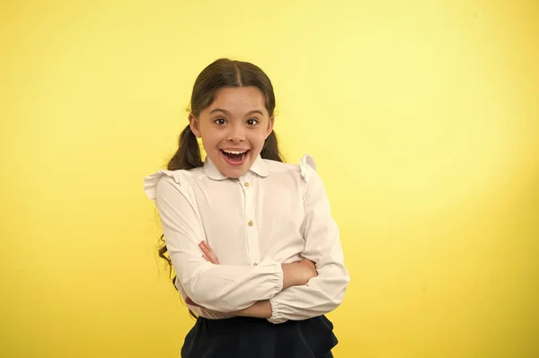 Amazing news. Girl school uniform smiling cheerful face wondering yellow background. Child excited back to school end continue education. Schoolgirl formal outfit look cute. Girl happy back to school — Stock Photo, Image