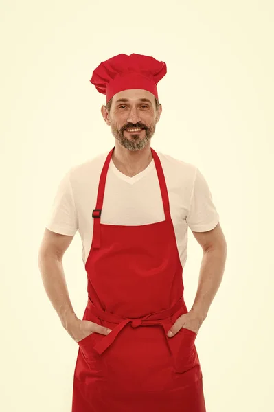 Limpiaré y cocinaré para ti. Hombre maduro barbudo en sombrero de chef y delantal. Cocinero senior con barba y bigote con delantal babero. Cocinero jefe maduro en delantal de cocina rojo. Cocina casera —  Fotos de Stock