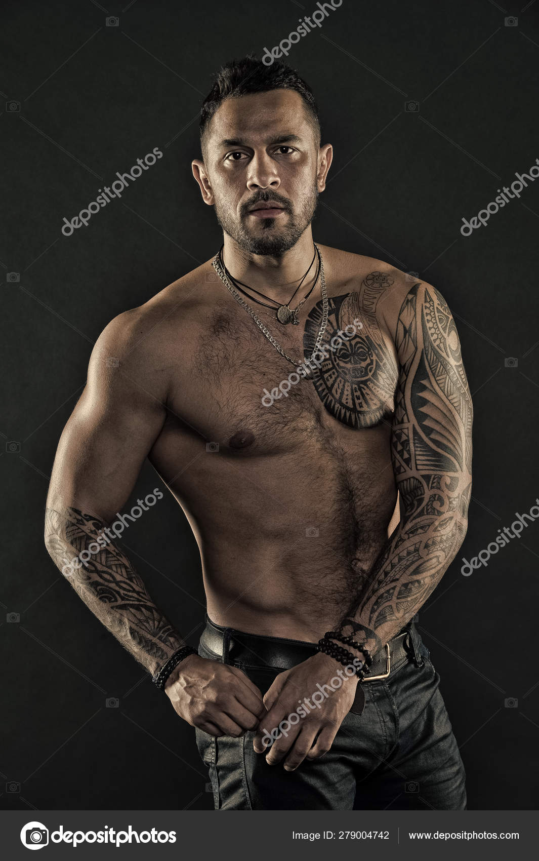Bearded man with tattooed body. Man with sexy bare torso in jeans. Tattoo model with six Bearded man with tattooed body. Man with sexy bare torso in jeans. Tattoo model with six
