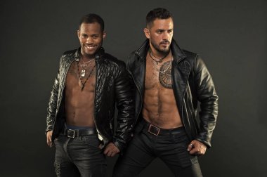 Erkekler gülümseyen yüzler kıl ve dövmeler ile üzerinde. Moda ve stil kavramı. Seksi kas torsolar erkeklerle vahşice bak. Maço kas torsolar ile deri ceketler, koyu arka plan çekici bakmak