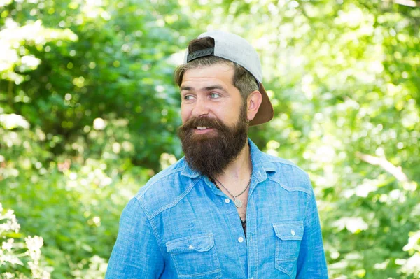 La barba folta e 'fantastica. Felice ragazzo caucasico con la barba su sfondo naturale. Uomo barbuto sorridente con baffi alla moda e la forma della barba. hipster non rasato con barba capelli strutturati in estate all'aperto — Foto Stock