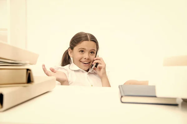 Usando novas tecnologias de comunicação na educação escolar. Menina pequena falando no telefone celular na lição. Uma criança de escola pequena a fazer um telefonema. Estudante desenvolvendo habilidades de comunicação. Estar em uma chamada — Fotografia de Stock