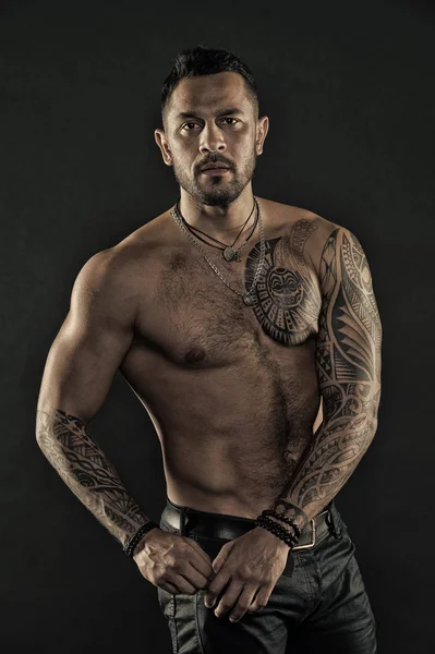 Uomo barbuto con corpo tatuato. Uomo con torso nudo sexy in jeans. Modello tatuaggio con sei pack e ab. Atleta o sportivo con petto e pancia muscolosi. Sport o fitness e cura del corpo, filtro vintage — Foto Stock