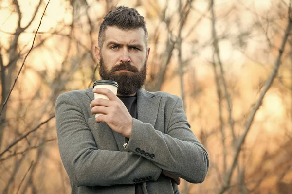 Drick det på språng. Mannen skäggig hipster föredrar kaffe ta bort. Affärsman dricker kaffe utomhus. Laddar energi. Avkopplande kaffepaus. Hipster hålla papper kaffekopp och njuta av naturen miljö — Stockfoto
