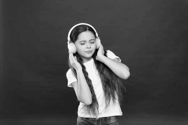 彼女のお気に入りの音楽を楽しんでいます。ステレオ ヘッド フォンを身に着けている小さな女の子。女の子は、音楽を聴きます。ワイヤレス ヘッドセットとかわいい音楽ファン。小さな子供のレジャーや教育のための技術を使用して — ストック写真
