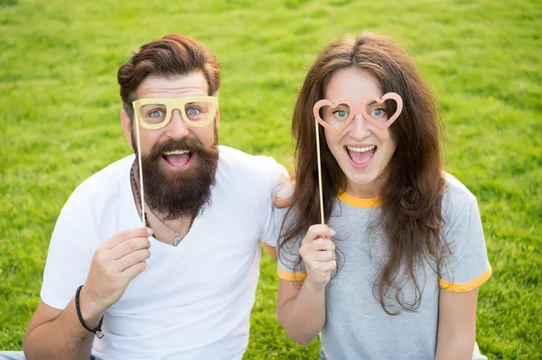 Love story. Couple relaxing green lawn. Man bearded hipster and pretty woman in love. Summer vacation. Emotional couple radiating happiness. Happy together. Couple in love cheerful youth booth props