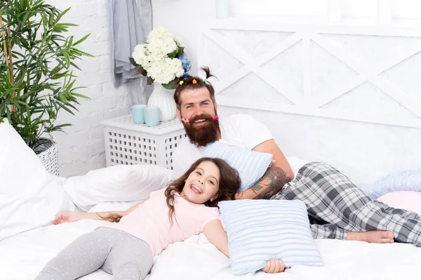 幸せな父性男はパジャマで子供っぽい髪型カラフルなポニーテールと娘とヒップスターをひげを生やしました。眠れるパーティー寝室でくつろぐ男と女の子。パジャマスタイル。楽しいパジャマパーティーを持っている — ストック写真