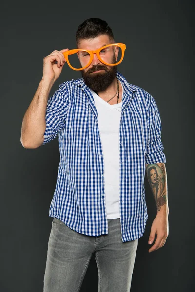 The glasses are dressing for your face. Bearded man wearing party glasses on grey background. Cool party hipster with beard and mustache in fancy glasses. Stylish guy looking through fashion glasses