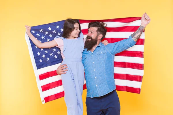 アメリカ人はどのように独立記念日を祝うのですか。父はヒップスターと宇佐旗を持つかわいい娘をあごひげ。愛国的な家族は陽気でフレンドリーです。独立記念日の休日。独立は幸福 — ストック写真