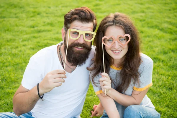 Homem barbudo hipster e mulher bonita apaixonada. Férias. Felizes juntos. Casal no amor adereços de cabine de jovens alegres. Casal emocional irradiando felicidade. História de amor. Casal relaxante gramado verde — Fotografia de Stock