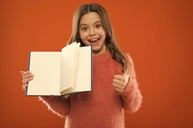 Daha fazla bilgi başlangıç. Kız kitap turuncu arka plan tutun. Çocuk gösteri sayfalar kitap veya Not defteri açın. Kitap mağaza konsepti. Ücretsiz kitaplar okumak kullanılabilir. Çocukluk edebiyat. Gelişimi ve eğitimi