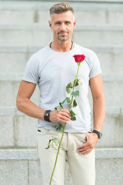 For someone special. Man with rose. Handsome man holding red rose. Attractive man with flower. Sexy man preparing natural gift for valentines day or birthday celebration