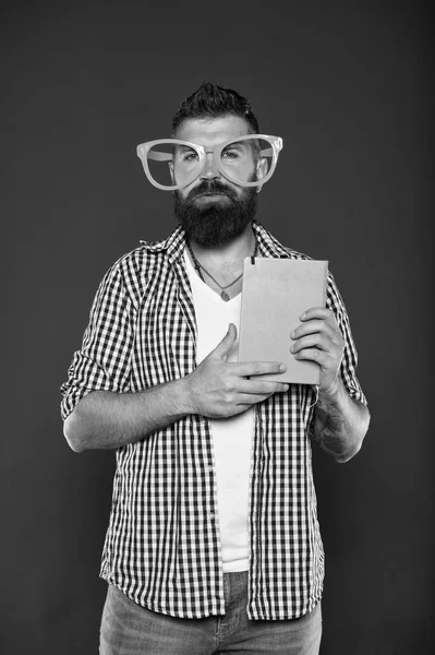 İnek yeni cool olduğunu. Kitap nerd çalışma. Kitap nerd süslü gözlük takıyorum. Üniversite erkek öğrenci ders notları ile. Adam ders kitabı ile parti bardaklarda sakallı