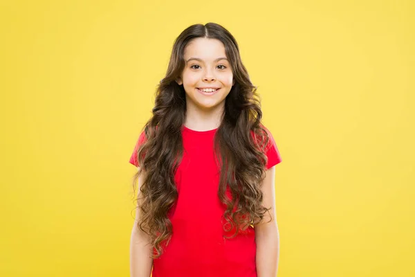 Salão de cabeleireiro. cuidados com a pele e cabelo natural. felicidade infantil. menina feliz com cabelo encaracolado longo. moda e beleza. Criança hipster. Uma menina a sorrir. cabeleireiro para pequeno fashionista — Fotografia de Stock