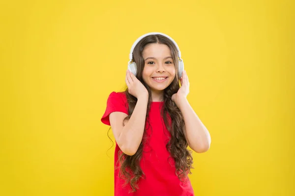 Top songs. Child teen enjoy music playing in earphones. Little girl enjoying favorite music. Catch the rhythm. Kid listening music headphones. Entertainment and fun. Excellent audio sound quality