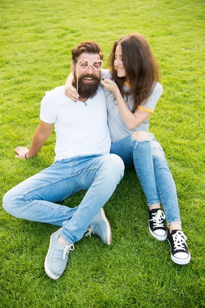 Casal emocional irradiando felicidade. História de amor. Casal relaxante gramado verde. Felizes juntos. Casal no amor adereços de cabine de jovens alegres. Homem barbudo hipster e mulher bonita apaixonada. Férias — Fotografia de Stock