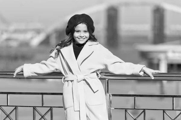 Elegante bambino in berretto e cappotto parigino. Una ragazzina all'aperto. Tempo primaverile. Tendenza autunno. Ragazzina felice. Look alla moda per bambini. Piccola donna d'affari. Piccola bellezza alla moda. Ragazza alla moda — Foto Stock