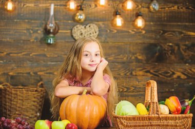 Çiftlik piyasa sonbaharda hasat. Hasat Festivali kavramı. Sepet taze sebze hasat rustik tarzı dolu yakınındaki kız evlat. Hasat onu sebze bahçe ahşap arka plan üzerinde sunulması kız çocuk