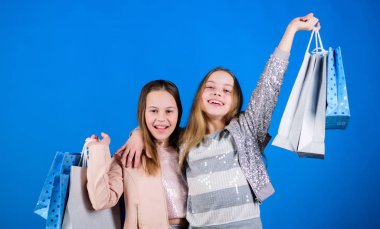 Başarı. Alışveriş poşeti olan küçük kızlar. Kardeşlik ve aile. satın almalarda tasarruf. Çocuk modası. Satışlar ve indirimler. Mutlu çocuklar. Küçük kız kardeş online alışveriş zevk. satış başarısı