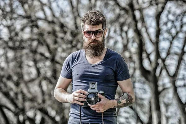 Fotógrafo segurar câmera vintage. Um blogueiro moderno. Criador de conteúdo. Fotógrafo hipster barbudo. Fotógrafo com barba e bigode. Homem de barba comprida a fotografar. Configurações manuais — Fotografia de Stock