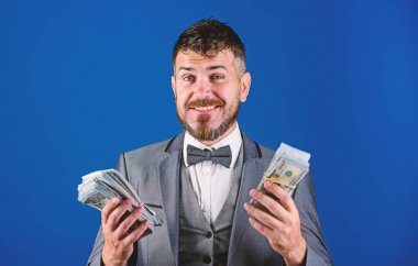 İşadamı nakit para var. Zenginlik ve refah kavramı. Nakit kolay ve hızlı bir şekilde olsun. Nakit işlem iş. Kolay nakit krediler. Resmi takım elbise tutun doları banknot yığını mavi arka plan