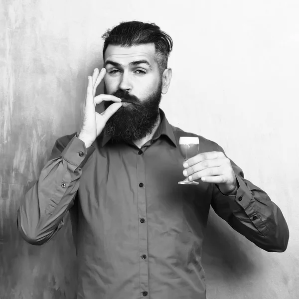 Bearded Man, lange baard. Brutale Kaukasisch tevreden hipster met snor in bruin shirt Holding alcoholische rode geschoten op kleurrijke textuur backgroun — Stockfoto