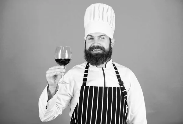 Sommelier undersöker vin. Detta vin är perfekt. Professionell kock i kock uniform. Självsäker manliga sommelier undersöka glas med vin. Glad skäggig man. Alkoholhaltig dryck. Rött vin i glas — Stockfoto