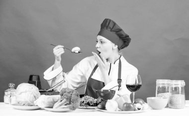 Mutfak masasındaki kız. Yemek pişirmek ve temizlik. Ev hanımı rutini. Profesyonel pişirme ipuçları. Kadın şef yemek yemeyi deneyin. Lezzetli tarifi kavramı. Yemek pişirmek. Sağlıklı yemek pişirme