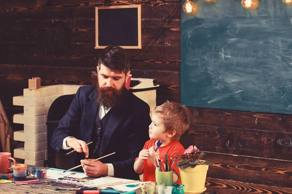 Papi y niño pintando la naturaleza. Padre e hijo en la lección de terapia de arte — Foto de Stock