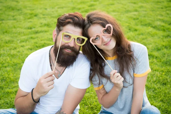 Casal emocional irradiando felicidade. História de amor. Casal relaxante gramado verde. Homem barbudo hipster e mulher bonita apaixonada. Férias. Felizes juntos. Casal no amor alegre jovens adereços cabine — Fotografia de Stock