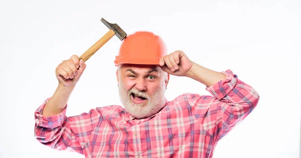 Чоловік бородатий працівник носить шолом, тримаючи молоток. Ремонтна майстерня. Концепція ремонту. Старший працівник виконкому. Ремонт домашнього майстра. Досвідчений інженер. Ремонт або реконструкція. Ремонт будинку — стокове фото