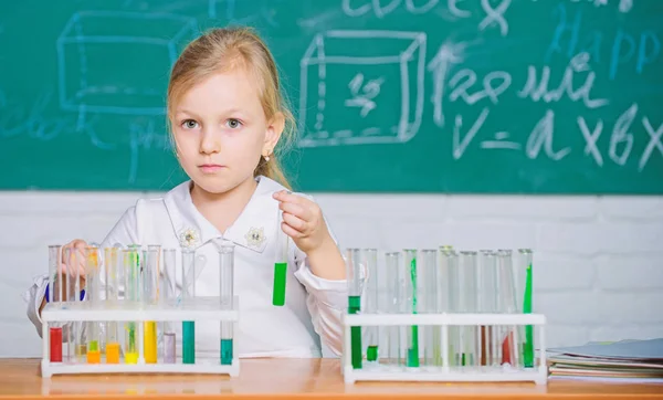 Experiência química na escola. Educação escolar. Abordagem interessante para aprender. Futuro cientista. Explorar e investigar. Lição escolar. Menina bonito aluno da escola brincar com tubos de ensaio e líquidos coloridos — Fotografia de Stock