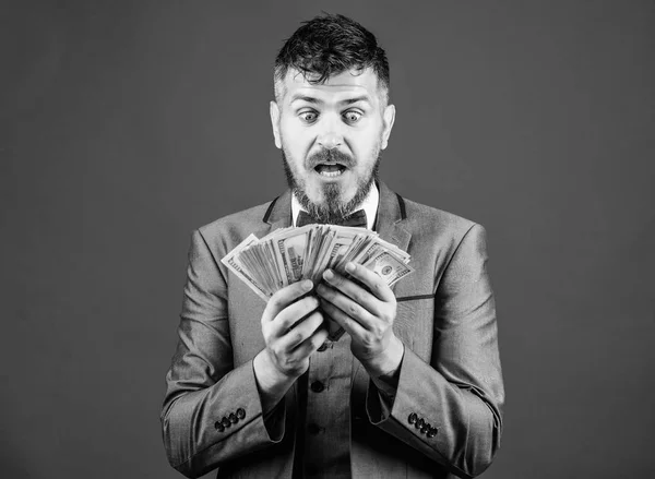 Is it all mine. Rich businessman with us dollars banknotes. Currency broker with bundle of money. Bearded man holding cash money. Making money with his own business. Business startup loan