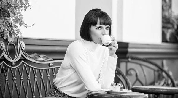 Delizioso e gustoso spuntino. Ragazza relax caffè con caffè e dessert. Concetto di dessert. Donna attraente elegante bruna godere dessert e caffè terrazza sfondo. Piacevole tempo e relax — Foto Stock