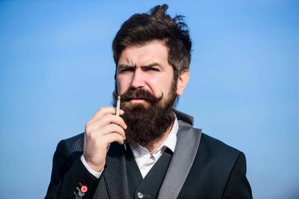 Hipster barbu fumant cigarette fond bleu ciel. Guy avec cigarette profiter de l'influence de la nicotine. Plaisir de fumer. Habitudes relaxantes mais nocives. Homme avec barbe et moustache tenir cigarette — Photo